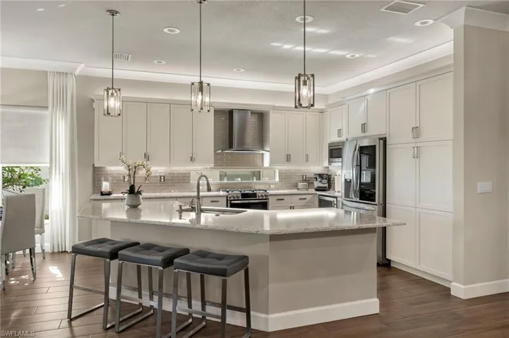 The window above the stove, the vent, wine cooler, and glass tile backsplash was an upgrade! Check out the brand new upscale fridge and brand new Bosch dishwasher! Bar seating for up to 7.
