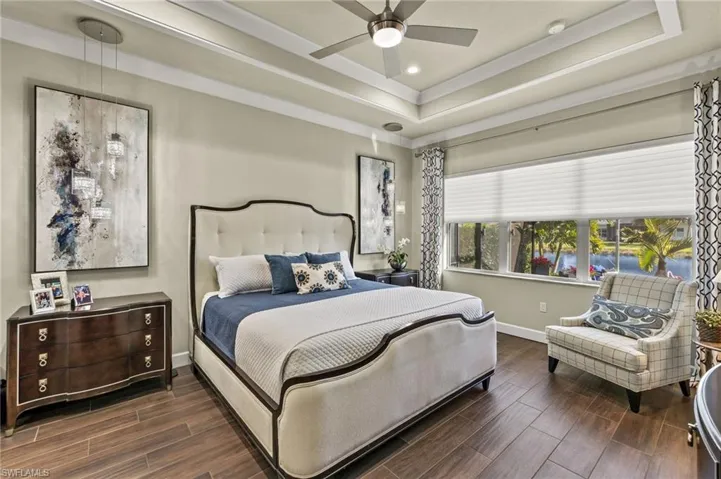 This primary bedroom oozes great taste...see the bedside lighting?  Custom window treatment, updated flooring, and tray ceiling too!