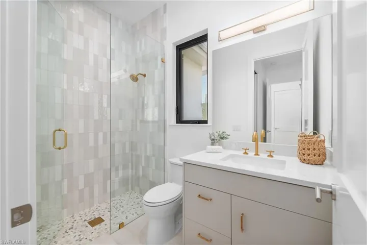 Full bathroom with toilet, a stall shower, and vanity