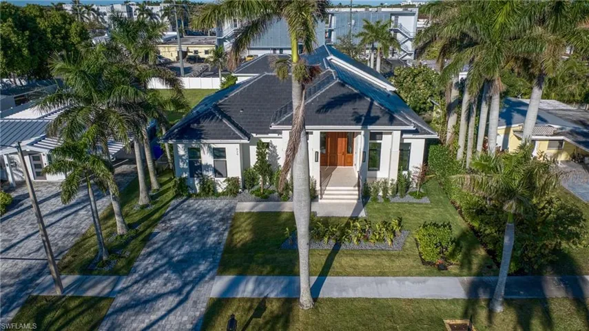 View of front of house featuring a front yard, decorative driveway, a residential view, and stucco siding