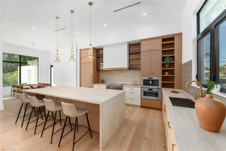 Kitchen with a sink, modern cabinets, oven, and open shelves