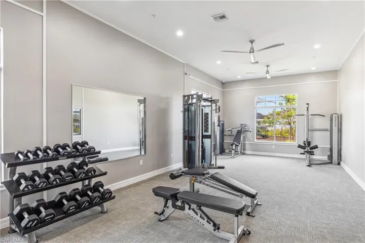 Workout room with a ceiling fan, carpet, baseboards, and recessed lighting