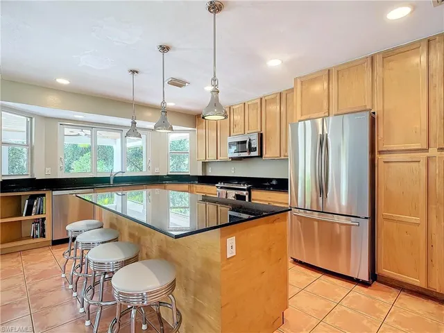 Eat-in Kitchen featuring, pendant light lighting and tile patterned floors, a kitchen island, and stainless steel appliances