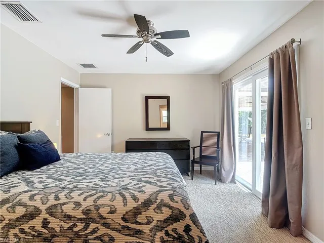 Bedroom with light carpet, ceiling fan, and access to outside