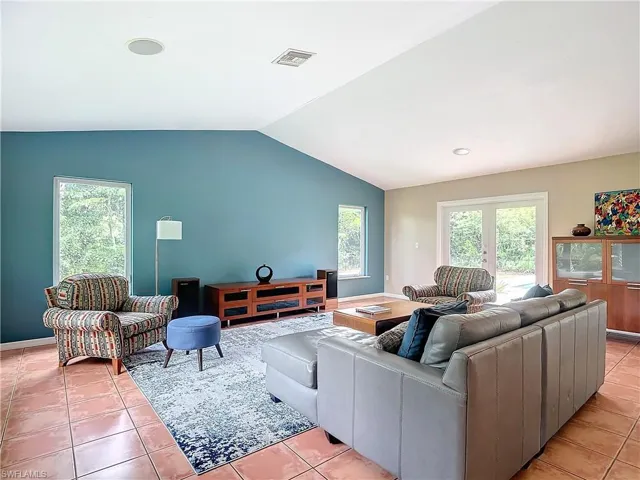 Living room featuring tile flooring and vaulted ceiling