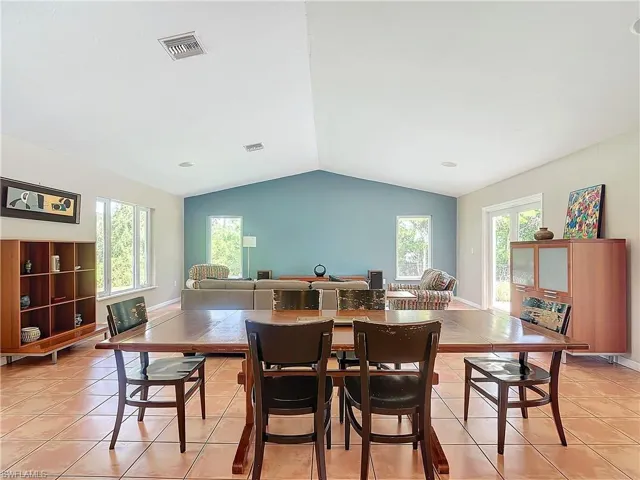 Tiled dining room with lofted ceiling and plenty of natural light