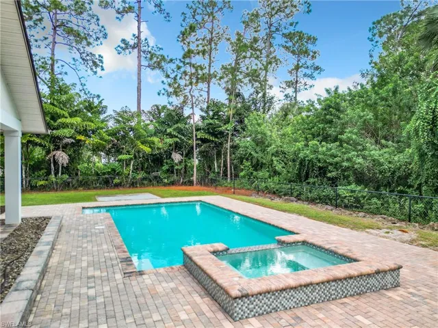 Southern exposure pool with an integrated hot tub and paver pool deck.