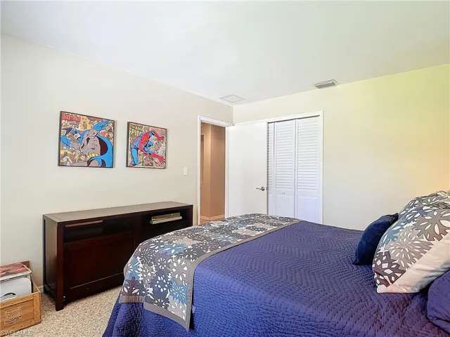 Carpeted bedroom with a closet