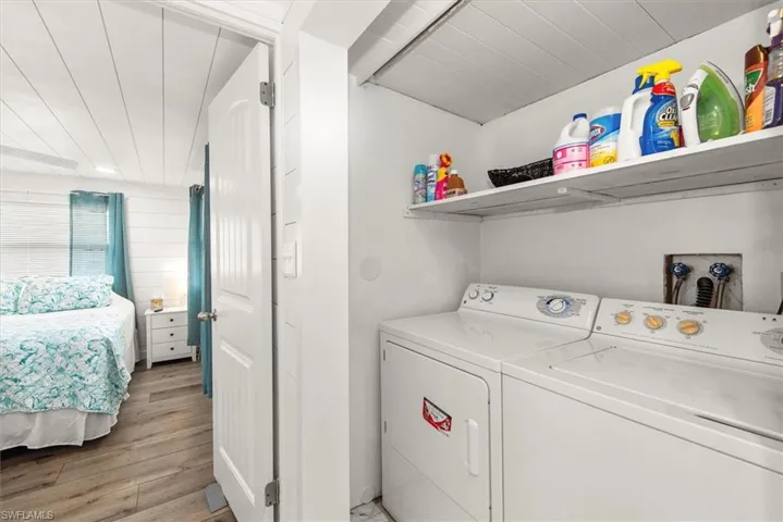 Laundry area with light wood-style flooring and washer and dryer