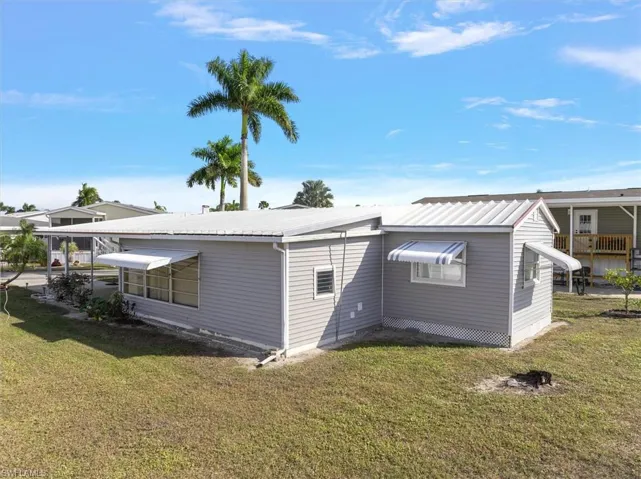 Rear view of property featuring a yard and a metal roof