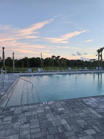 Pool at dusk with a community pool and a patio area