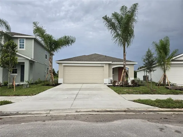 View of front of home featuring concrete driveway, an attached garage, stucco siding, a shingled roof, and a front lawn