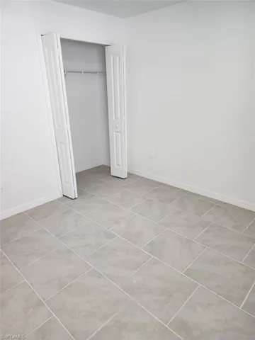 Unfurnished bedroom featuring a closet and light tile patterned floors