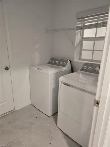 Laundry area featuring washer and dryer and light tile patterned floors