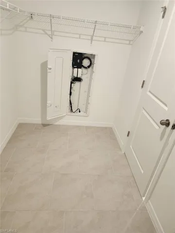 Laundry area featuring a garage and light tile patterned floors