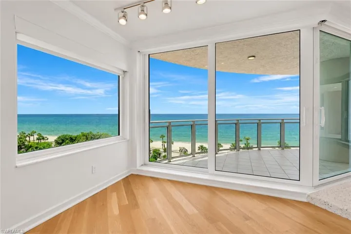 Wood-finish flooring, white walls, large window, sliding glass doors, and recessed lighting