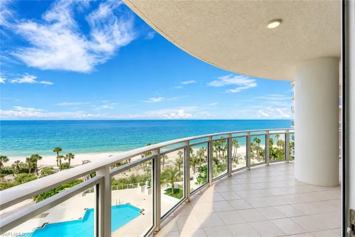 Curved balcony with glass railing, tiled flooring, and a recessed ceiling light