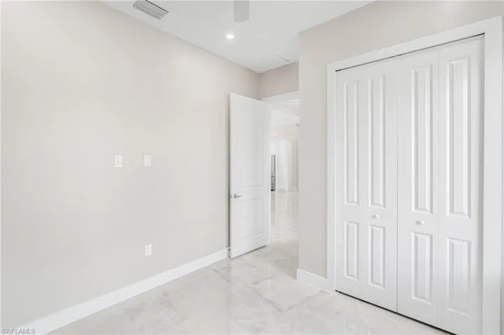 Unfurnished bedroom with ceiling fan and a closet