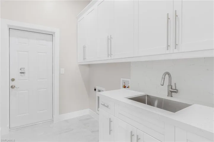 Laundry area featuring cabinets, hookup for a washing machine, sink, and electric dryer hookup