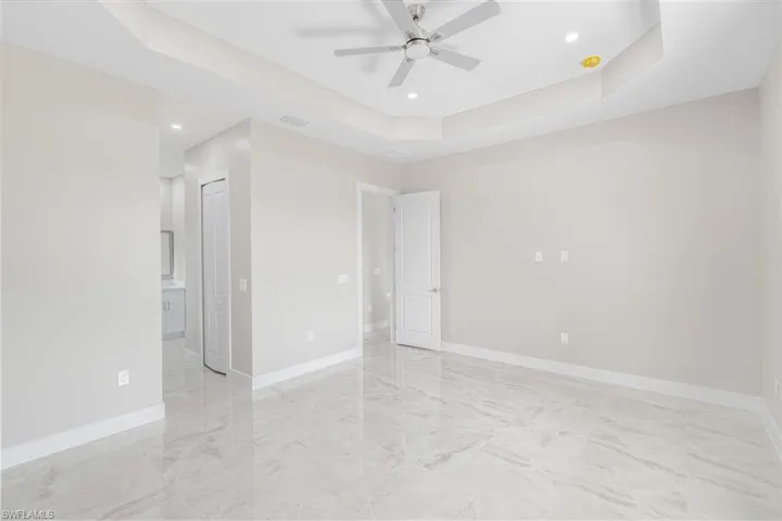 Empty room with a tray ceiling and ceiling fan