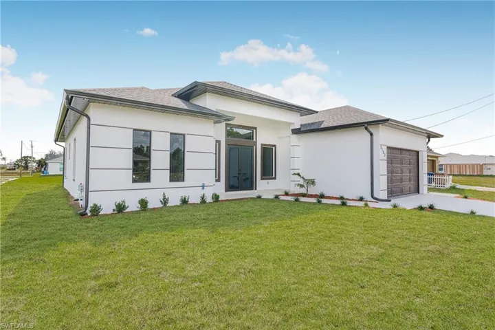View of front of house featuring a garage and a front yard