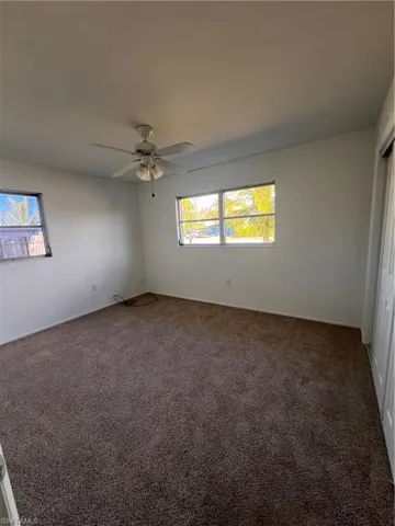 Spare room featuring carpet floors, a wealth of natural light, and ceiling fan