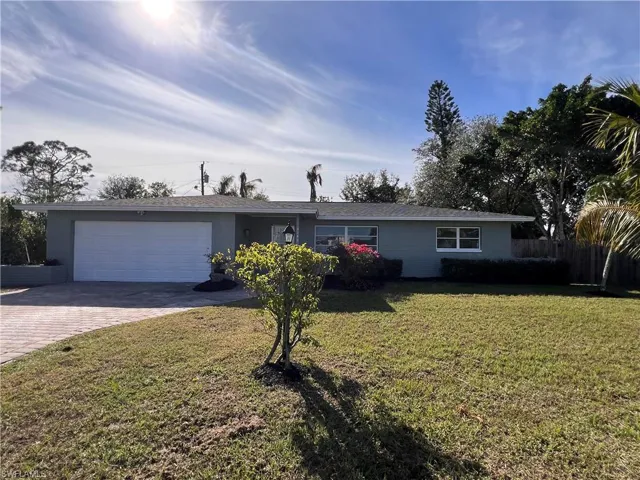 Ranch-style home with a garage and a front lawn
