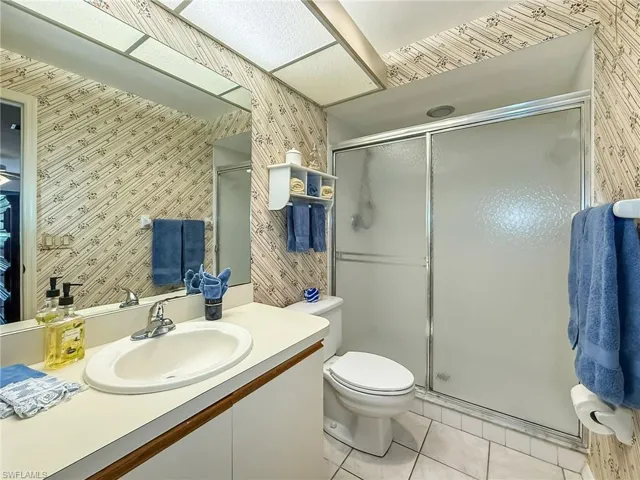 Bathroom featuring vanity, an enclosed shower, tile patterned floors, and toilet