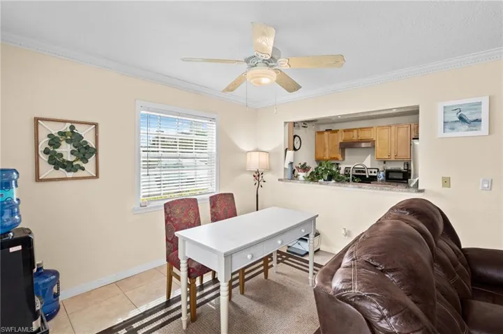 Dining space with ornamental molding, ceiling fan, and light tile patterned floors