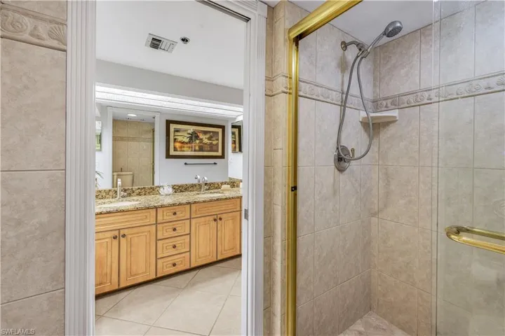 Master - Tile shower enclosure with a hand-held showerhead and gold-toned frame