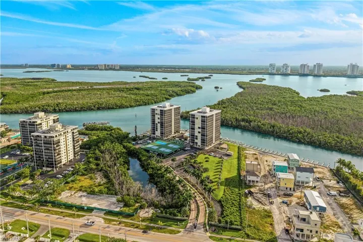 Coastal high-rise buildings, surrounding waterways, lush green islands, multiple building structures, and residential development