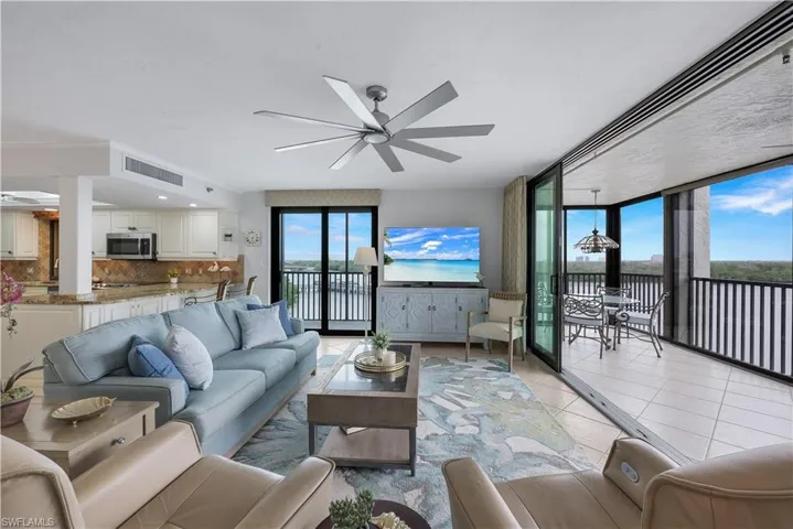 Open-concept living area with tiled flooring, a modern ceiling fan, and sliding glass doors leading to a private outdoor space