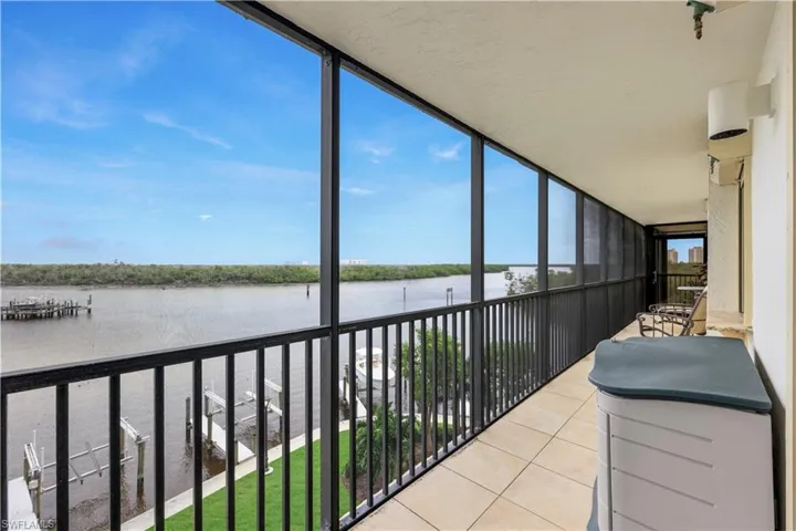 Screened balcony with tiled flooring and a metal railing