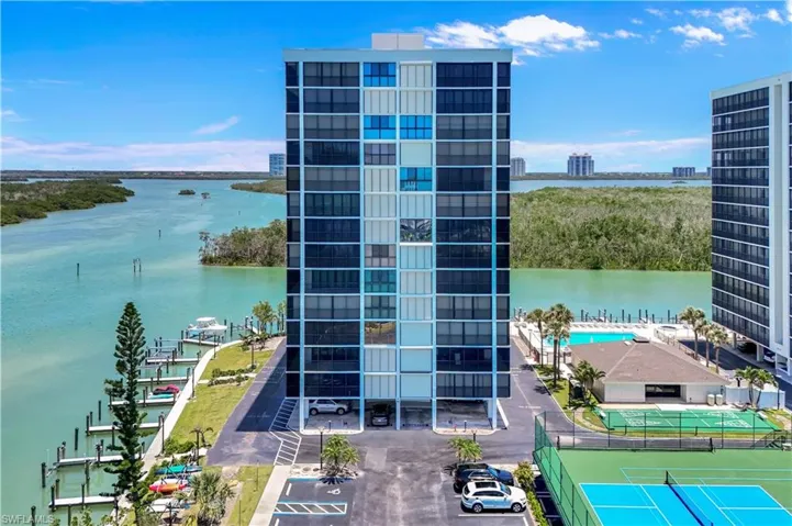 High-rise building with a water-facing orientation, private boat docks, a swimming pool, and a tennis court