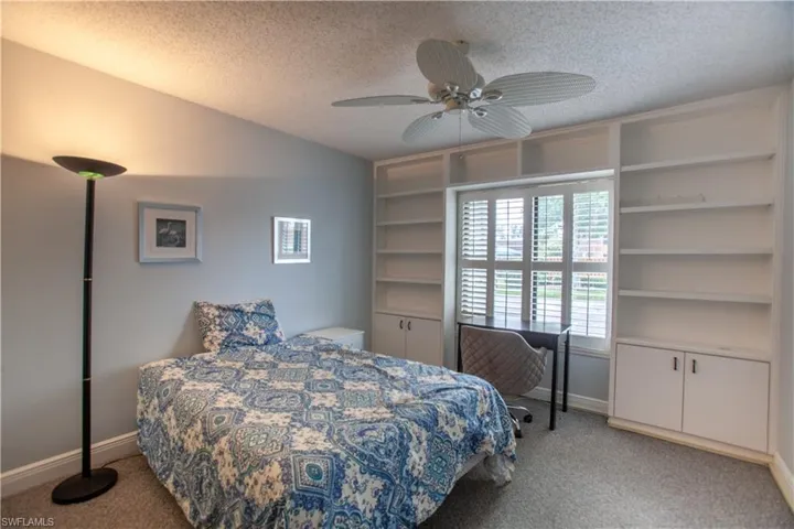 Bedroom featuring light carpet, a textured ceiling, and ceiling fan