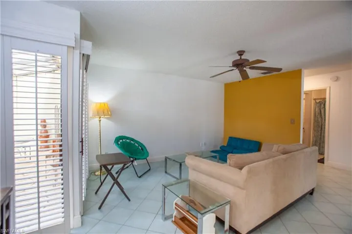 Living area featuring light tile patterned floors, a textured ceiling, and a ceiling fan