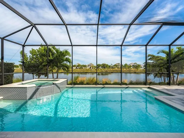 View of screened lanai with pool and spa and overlooking wide lake and beautiful home fronts on the other side of Antigua Way.