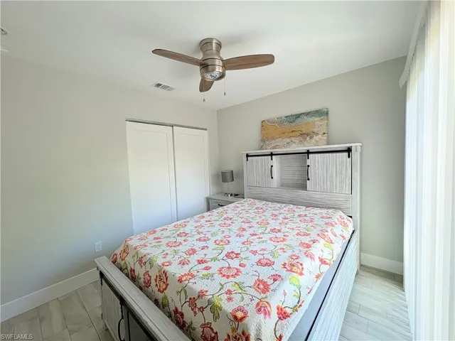 Bedroom with a closet, a ceiling fan, and light wood-style flooring