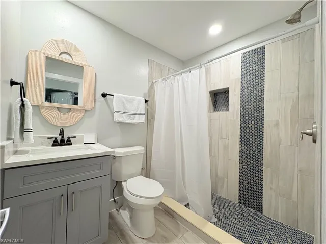 Bathroom featuring a stall shower, vanity, and recessed lighting