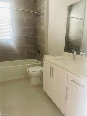 Bathroom featuring vanity, washtub / shower combination, and light tile patterned floors