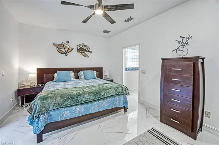 Tiled bedroom featuring ceiling fan