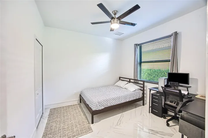 Bedroom featuring a closet, ceiling fan, and light tile floors