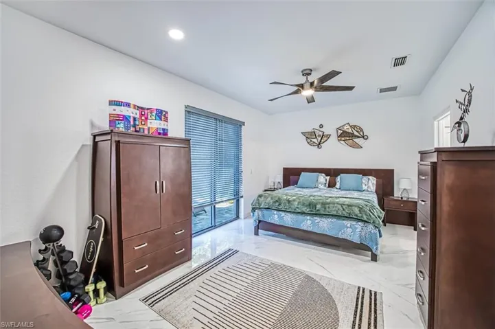 Bedroom with tile floors, ceiling fan, and access to outside