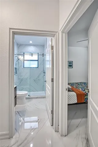 Bathroom featuring tiled shower, tile flooring, and toilet