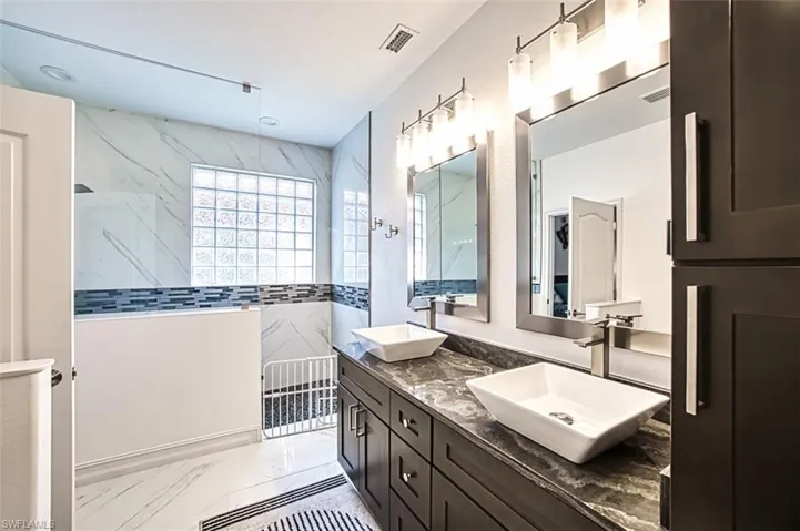 Bathroom featuring dual bowl vanity and tile floors