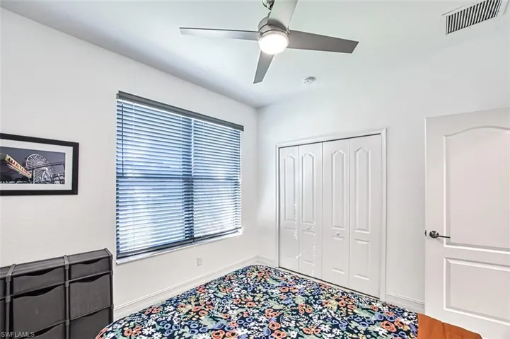Bedroom featuring a closet, ceiling fan, and multiple windows