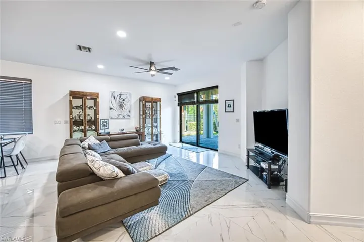 Living room with french doors, light tile flooring, and ceiling fan