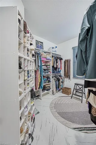 Spacious closet featuring tile flooring