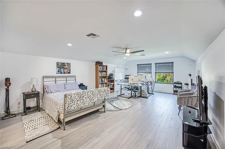 Bedroom featuring lofted ceiling, light wood-type flooring, and ceiling fan