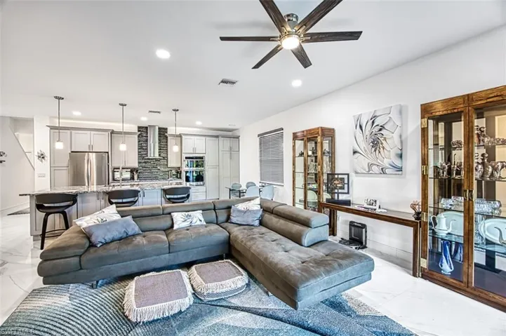 Living room with ceiling fan and light tile floors